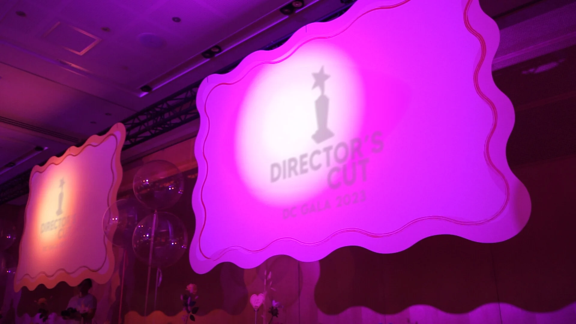 Illuminated Director’s Cut gala stage in vivid violet light.