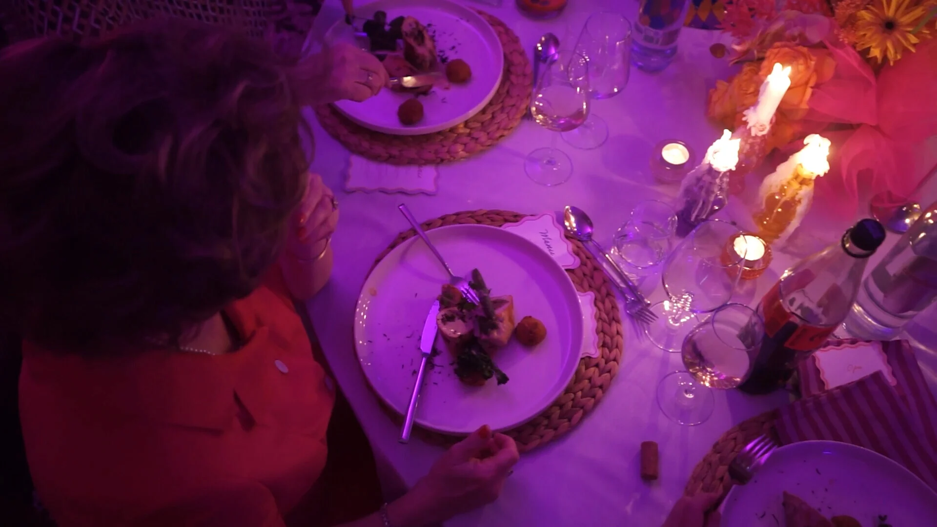 Guest dining at a candlelit Director’s Cut gala table, viewed from above.